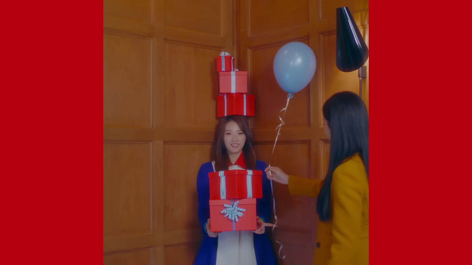 Haseul with presents stacked on top of her head.